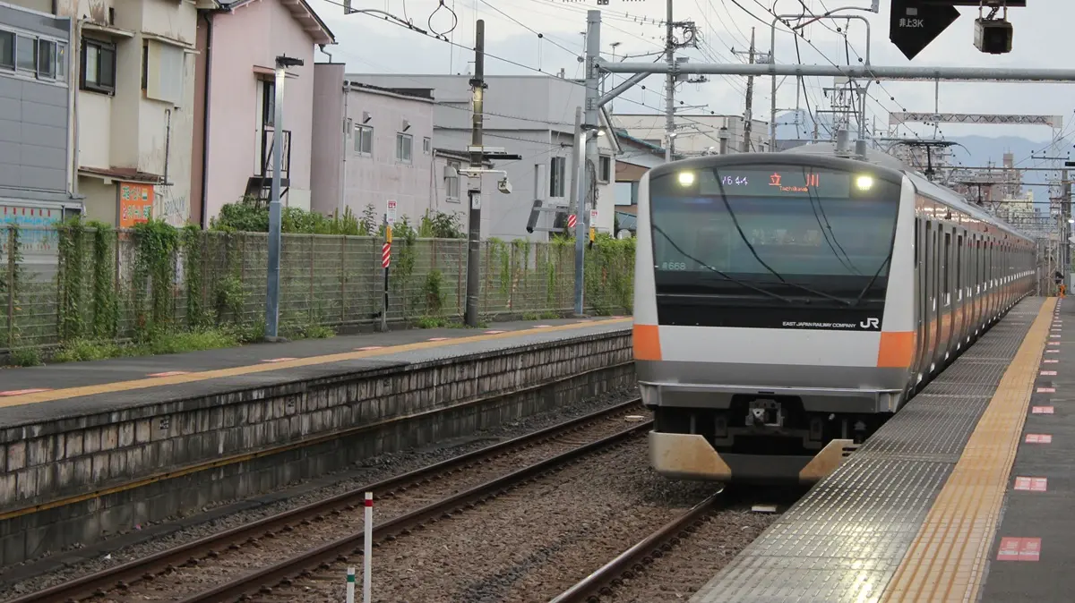 A six-car Itsukaichi Line E233 series train arriving at Higashi-Nakagami Station
