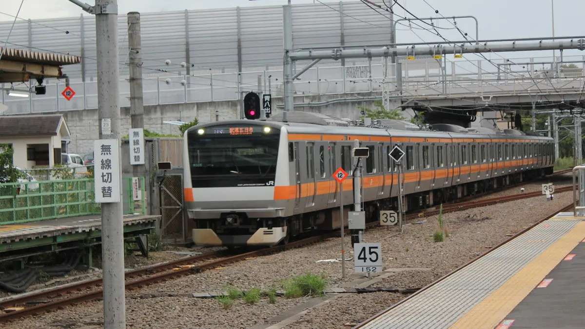 A six-car Itsukaichi Line E233 series train arriving at Haijima Station