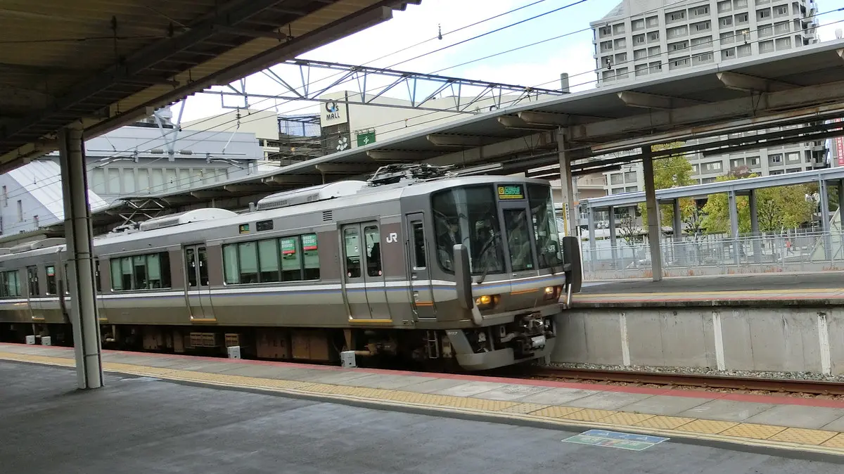 A JR 223 series train on the JR Takarazuka Line stopped at JR Amagasaki Station