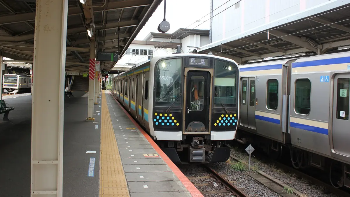 A Kashima Line E131 series train is stopped at Narita Station as a deadhead train
