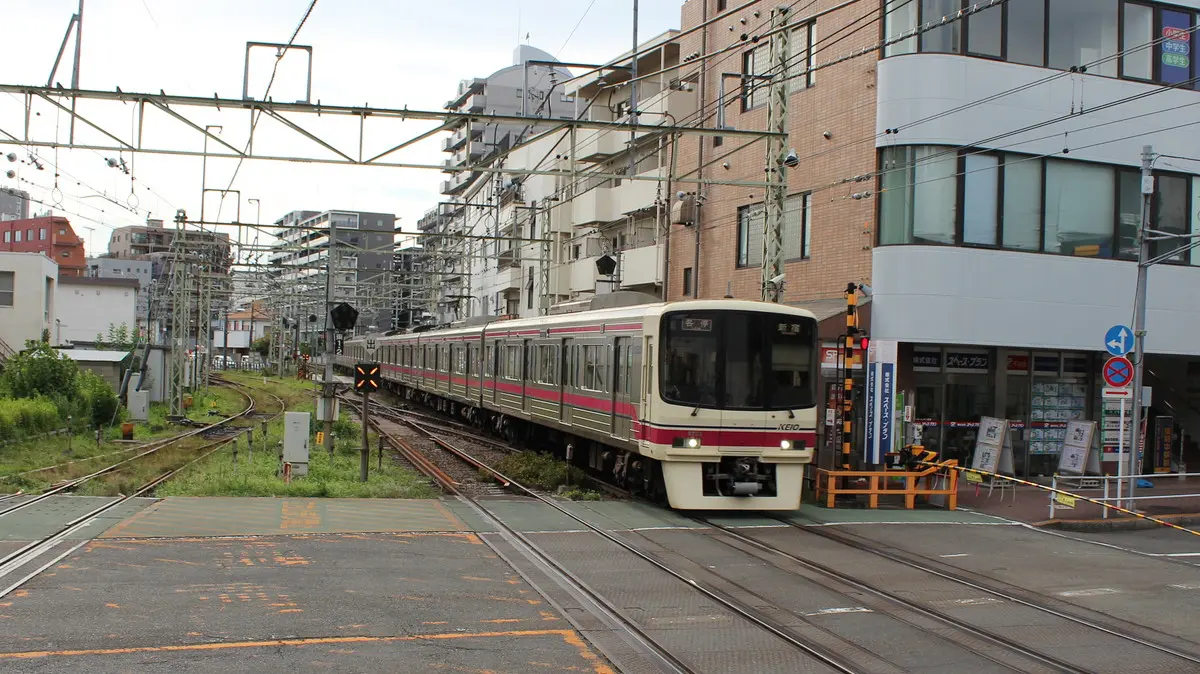 Keio Line 8000 series train running alongside the Keio Keibajo Line at Higashi-Fuchu Station