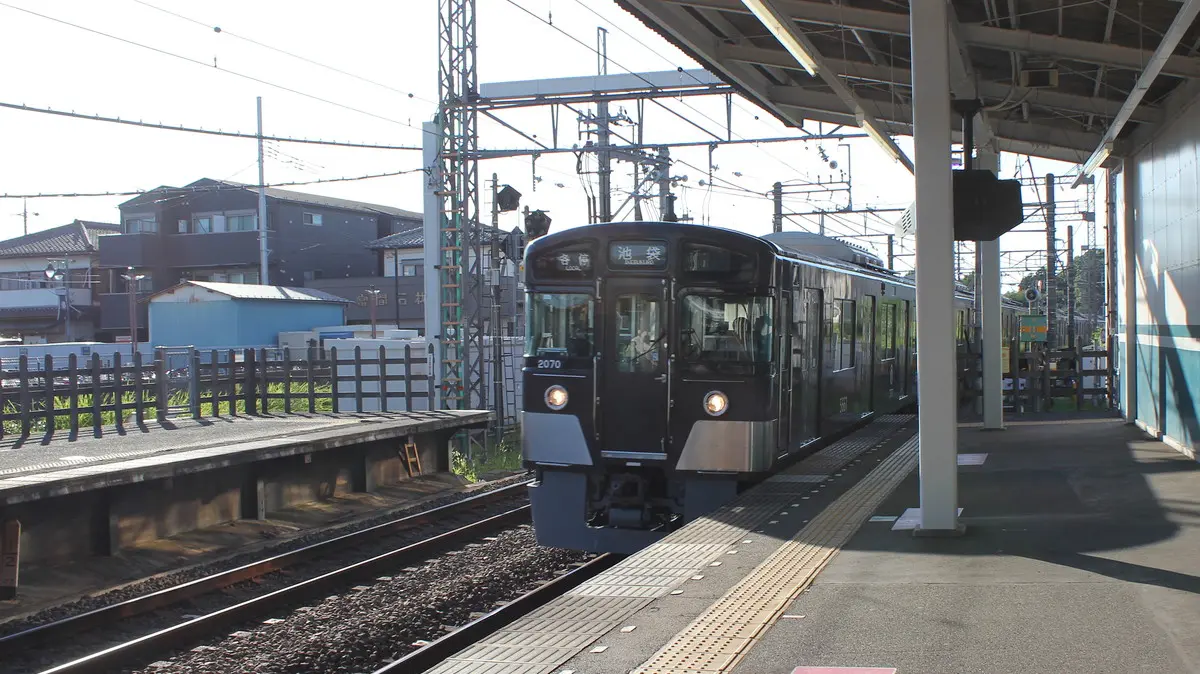 西所沢駅に入線する黒いラッピングの西武池袋線2000系電車