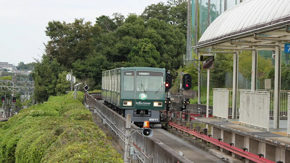 A green Leoliner 8500 series train arrives at Seibu Kyoujo-mae Station