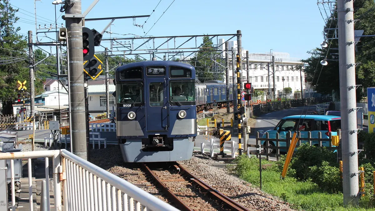 A black-wrapped Seibu Tamako Line 2000 series train heading towards Hagiyama Station
