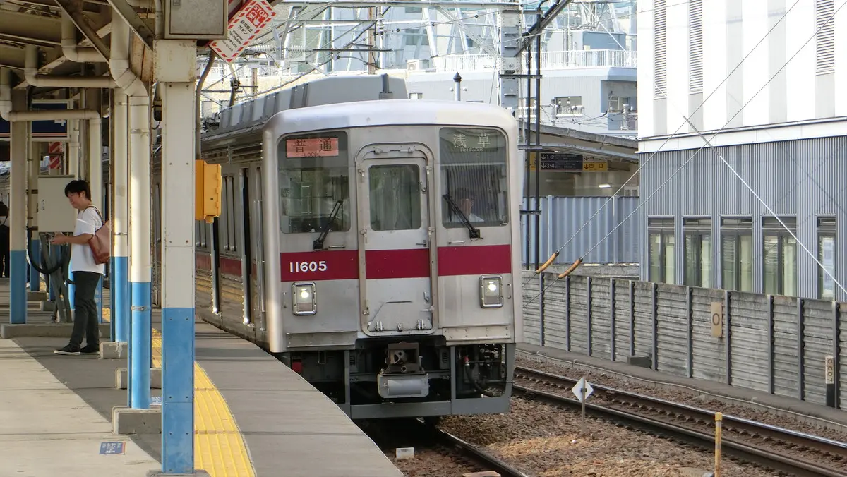 A 10000 series train, the same model as the Tobu Daishi Line, arrives at Hikifune Station