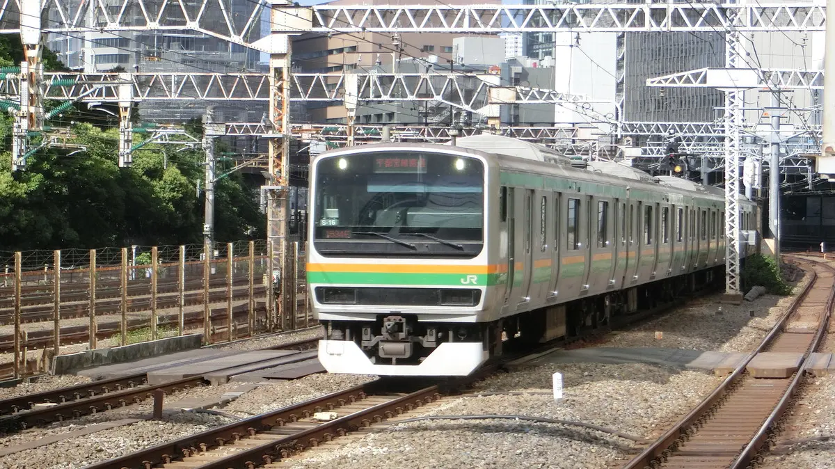 JR Utsunomiya Line E231 series 1000 train passing through Tamachi Station